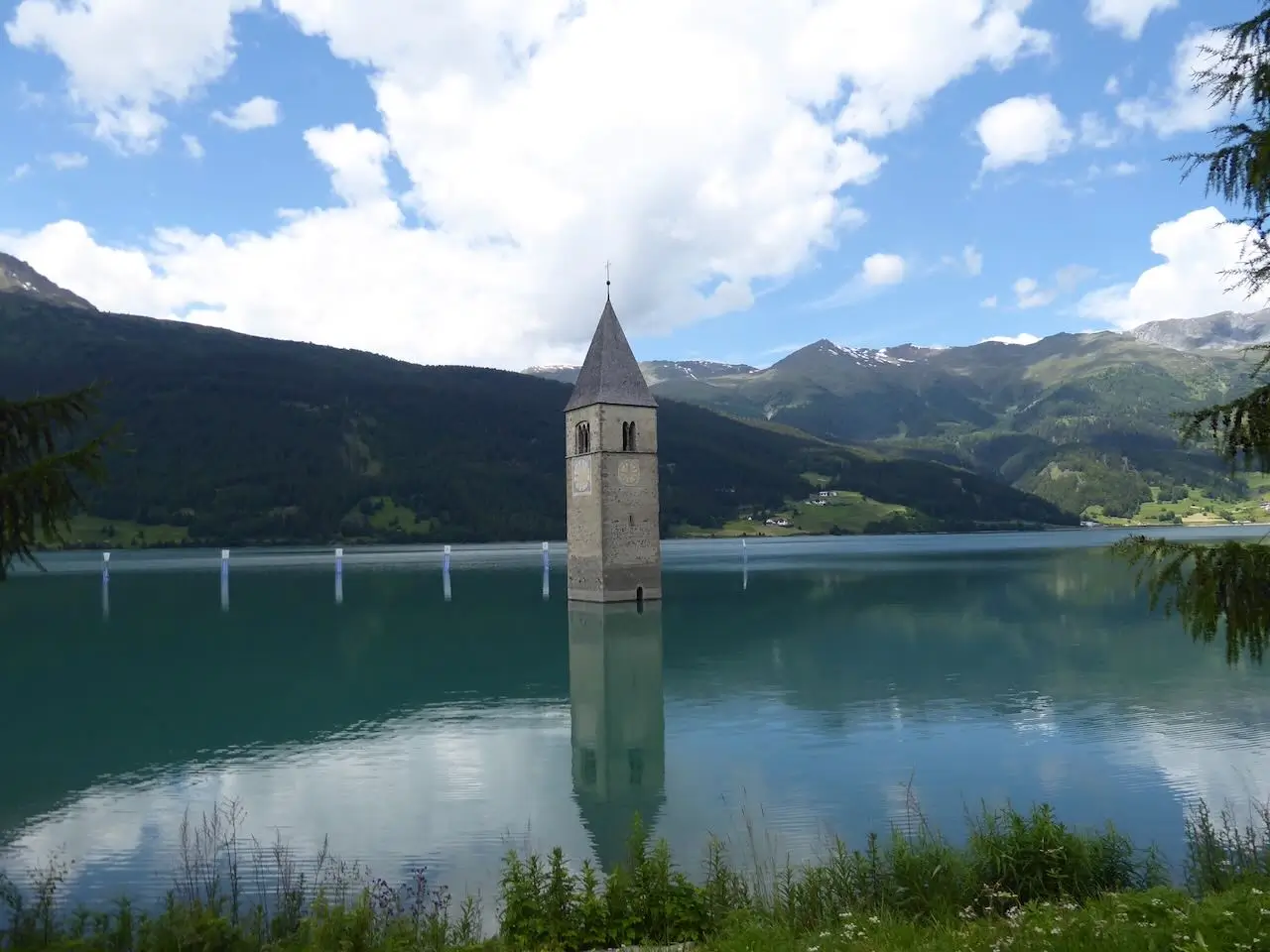 Anreise mit dem Auto zum Gardasee und nach Italien: Kirchturm im Wasser am Reschenpass